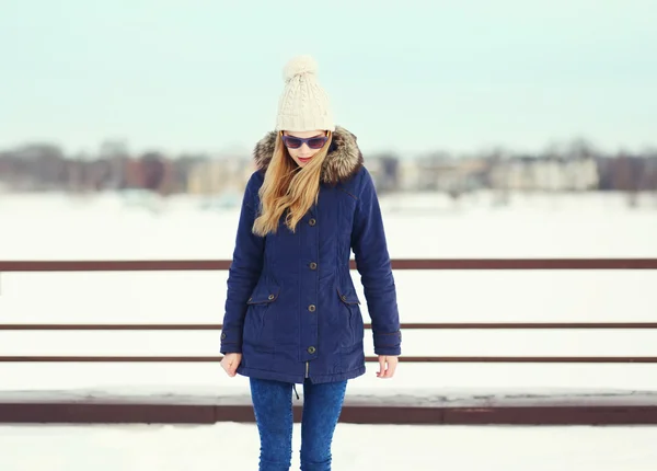 Menina loira bonita vestindo um casaco, chapéu e óculos de sol ao ar livre — Fotografia de Stock
