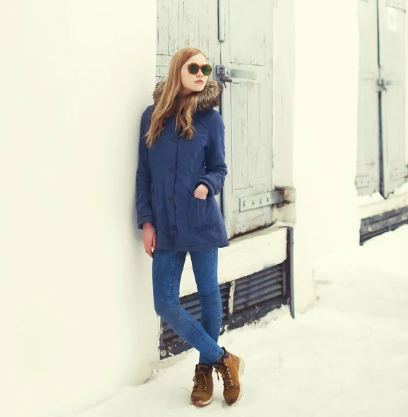 Mooie blonde vrouw een jas en zonnebril dragen in stad — Stockfoto