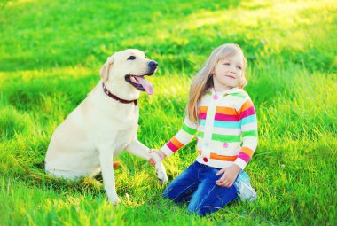 Labrador geri almak köpeğe otların arasında yaz günü ile mutlu çocuk