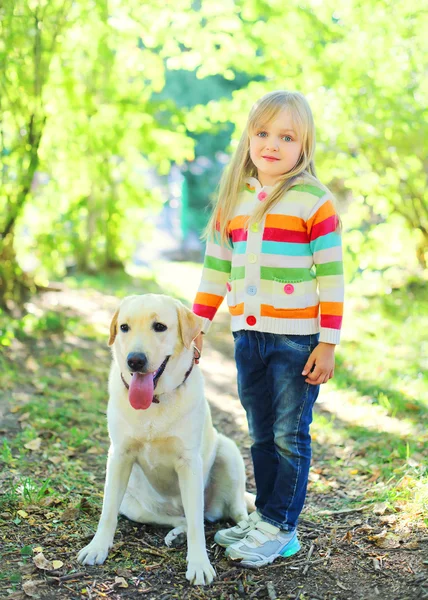 Happy labrador retriever dog and little child in summer day — Stock Photo, Image