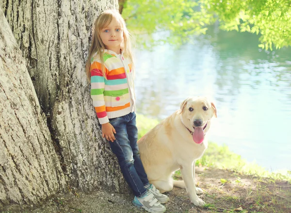 Criança pequena com cão Labrador retriever e no parque de verão — Fotografia de Stock