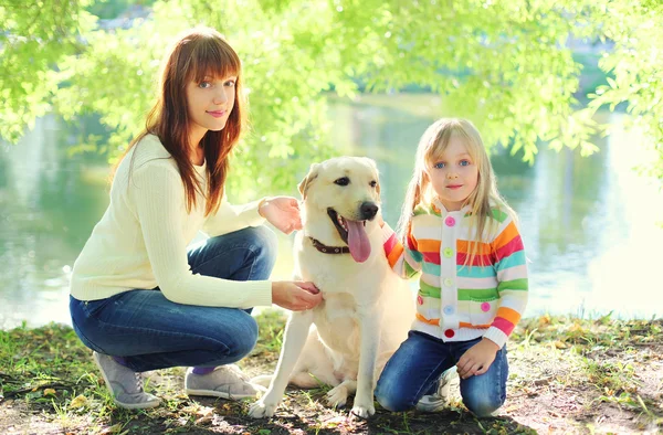 Mother and child with Labrador retriever dog and in summer park — Stock Photo, Image