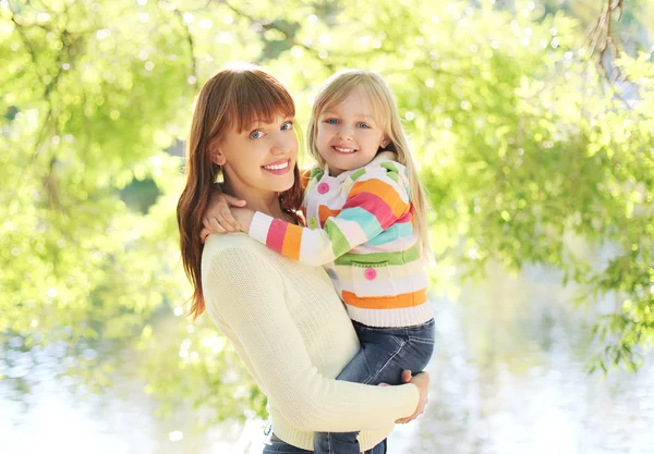 Portret gelukkig lachend moeder en kind knuffelen in zomerdag — Stockfoto