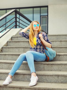 Pretty genç kız bir kareli gömlek, bac ile güneş gözlüğü takıyor