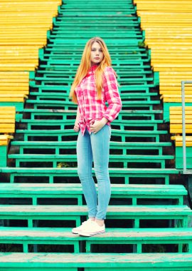 Şehirde damalı pembe gömlek ve pantolon giyen genç kız