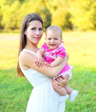 Güneşli portre anne ve bebek yaz aylarında birlikte gülümseyen mutlu 
