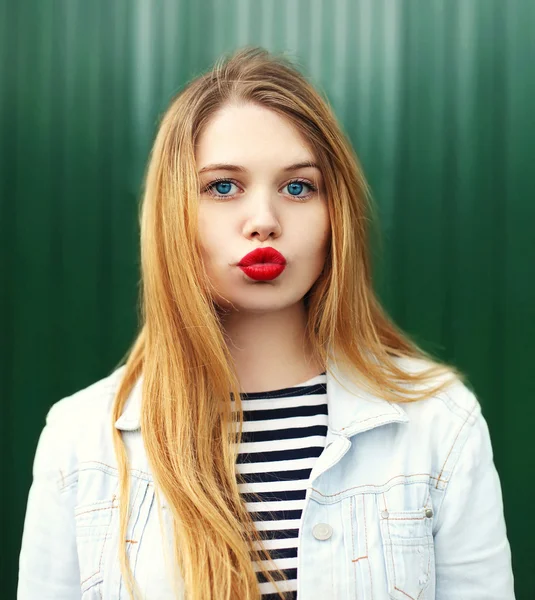 Retrato rubia joven con lápiz labial rojo soplando labios —  Fotos de Stock