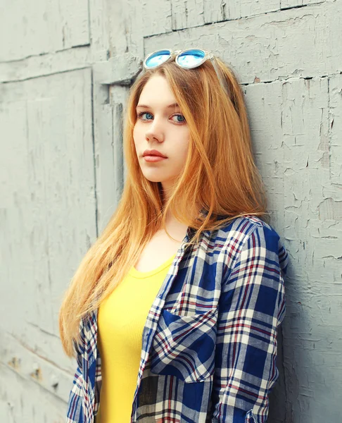 Portrait girl wearing checkered shirt and sunglasses in city — Stock Photo, Image
