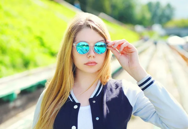 Portrait pretty young girl wearing a sport jacket and sunglasses — Stock Photo, Image