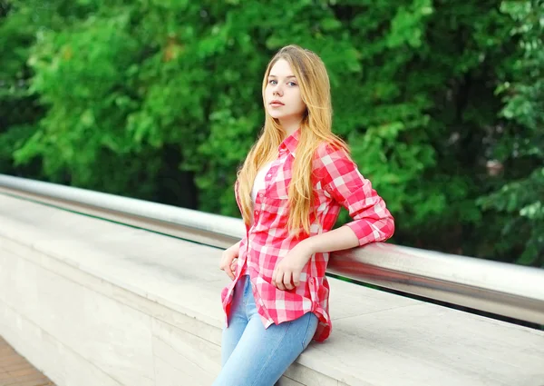 Fiatal lány visel rózsaszín kockás ingben szabadban városban — Stock Fotó