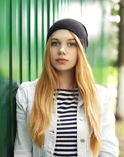 Young girl wearing a hat and jeans jacket outdoors in city — Stock Photo, Image