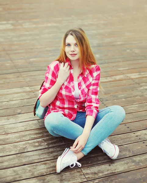 Mladá dívka, která nosí růžové tričko s batoh sedí spočívající v — Stock fotografie
