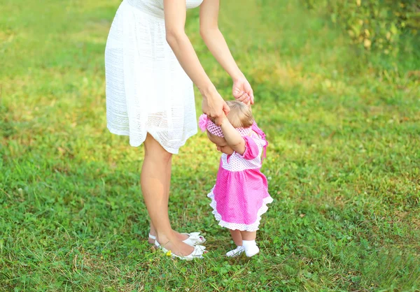 Beautiful mother and baby walking together on grass in summer da — Stock Photo, Image