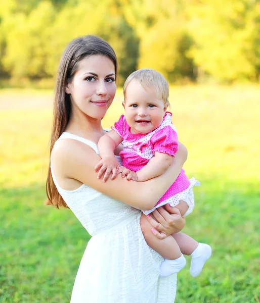 Sonniges Porträt glücklich lächelnde Mutter und Baby zusammen im Sommer — Stockfoto