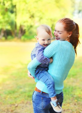 Mutlu gülümseyen anne ile oğlu çocuk birlikte açık havada park