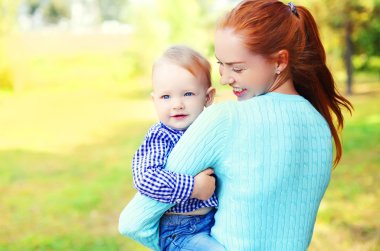 Portre mutlu gülümseyen anne ve oğlu çocuk açık havada park