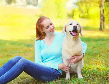 mutlu sahibi kadın ve Golden Retriever köpek çim beraber üzerinde oturan