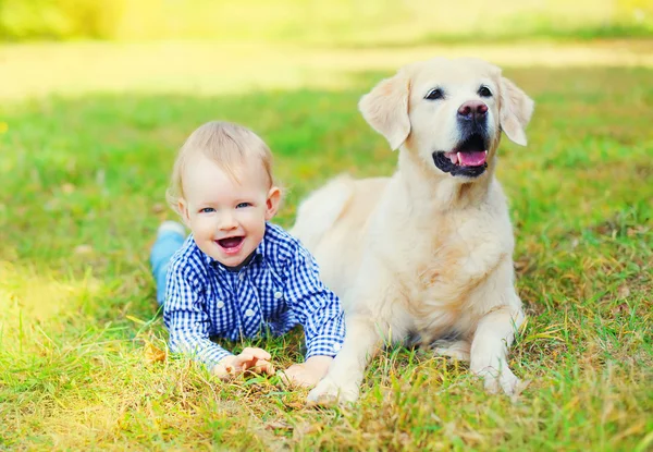 Mutlu küçük çocuk çocuk ve yan yana yatarken o Golden Retriever köpek — Stok fotoğraf