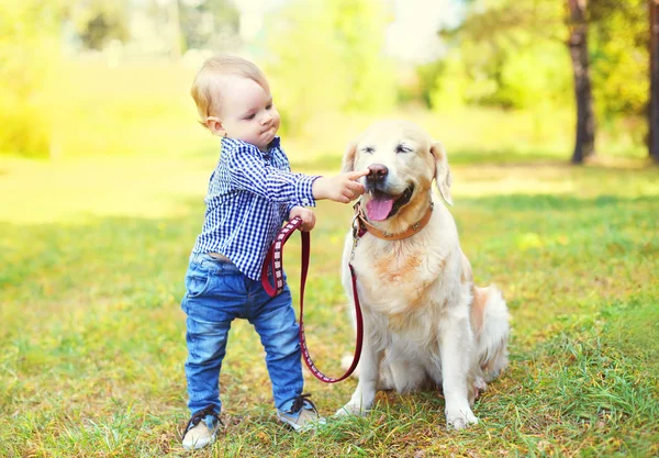 작은 소년 아이 p에 잔디에 골든 리트리버 강아지와 함께 연주 — 스톡 사진