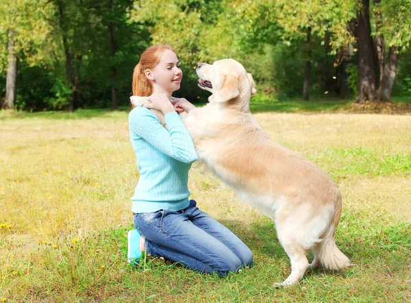 Golden Retriever köpek çimlerin üzerine oynamaktan mutlu sahibi kadın