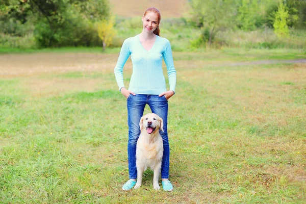 Счастливая хозяйка с собакой золотого ретривера, гуляющей вместе — стоковое фото