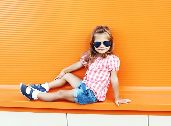 Niña de moda con gafas de sol y shi a cuadros — Foto de Stock