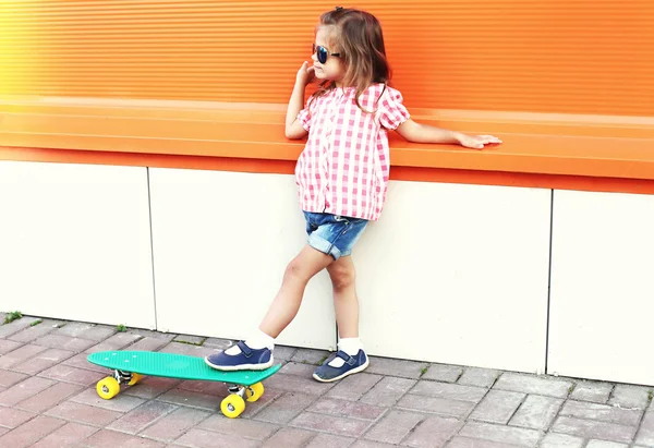 Divat divatos kislány gyerek gördeszka visel egy énekelt — Stock Fotó