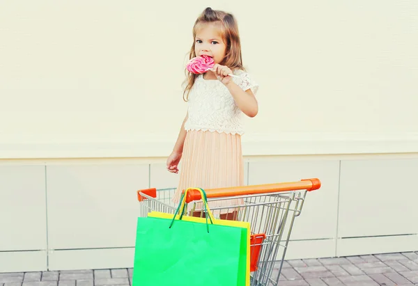 Happy little girl child with sweet caramel lollipop and colorful — Stock Photo, Image