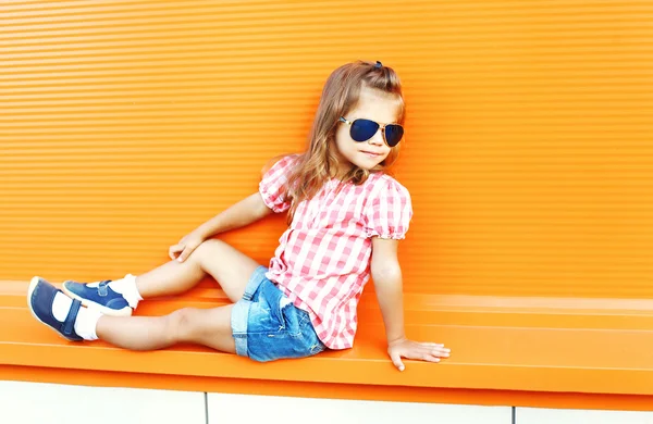 Elegante niño con gafas de sol y camisa a cuadros en la ciudad —  Fotos de Stock