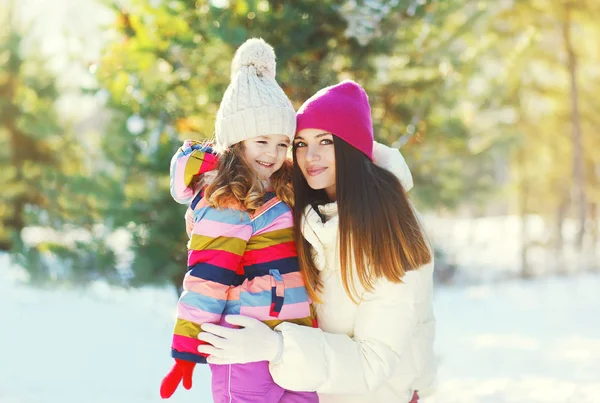 Счастливые улыбающаяся мать и ребенок дочь вместе зимой — стоковое фото