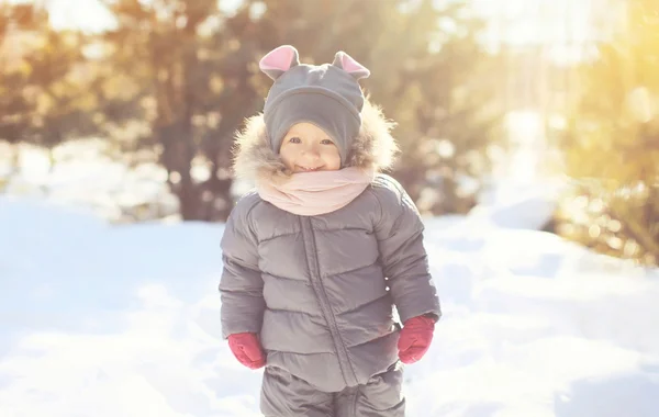 Fröhlich lächelndes kleines Kind, das im Wintertag spazieren geht — Stockfoto