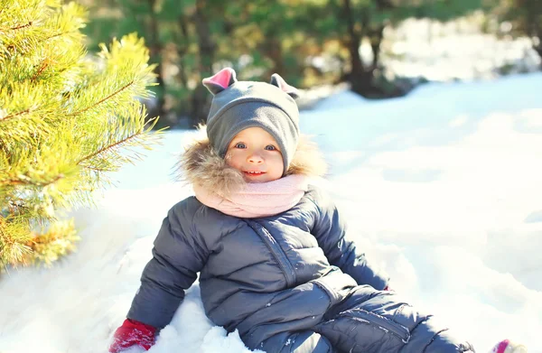 Glad lilla barn leker sitter på snö i vinterdag — Stockfoto