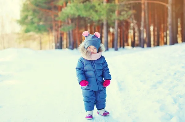 Anak kecil lucu berjalan di atas salju di hutan musim dingin — Stok Foto