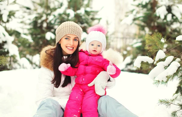 Gelukkig lachend moeder met kind op sneeuw in de winterdag — Stockfoto