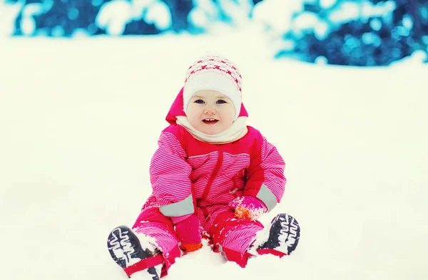 Glückliches Kind beim Spielen auf Schnee an einem verschneiten Wintertag — Stockfoto