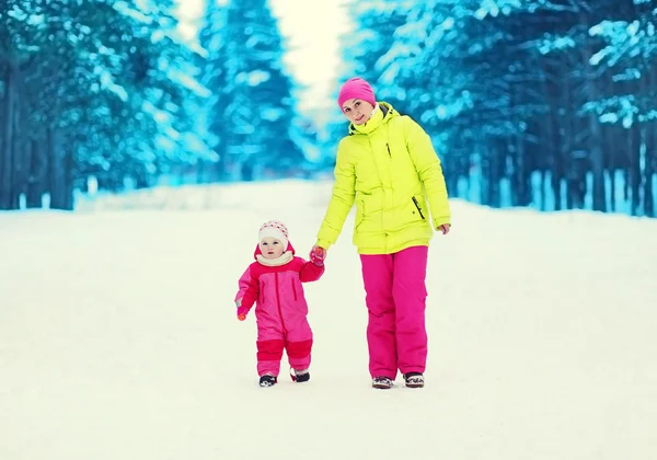 Lycklig mor och barn gå tillsammans i snörik vinter skog — Stockfoto