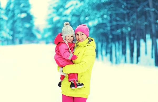 Happy leende mor och barn gå i snöig vinterdag — Stockfoto