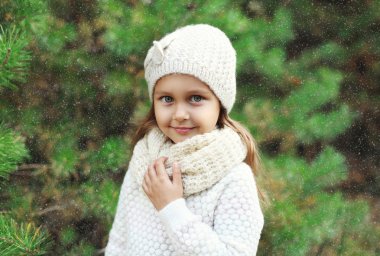 Little girl child wearing a knitted hat and sweater with scarf n