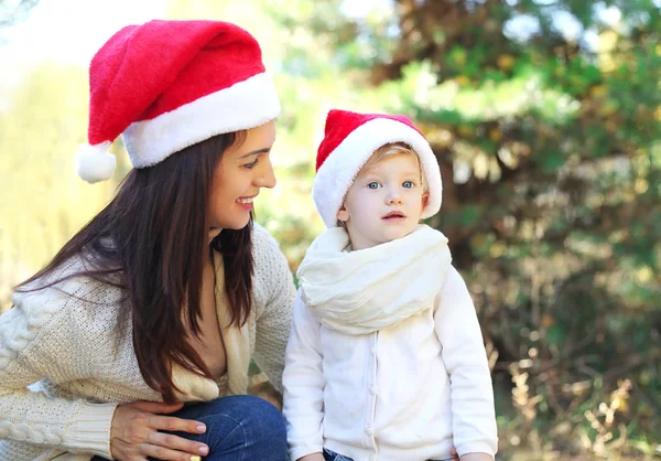 Conceito de Natal e família - mãe feliz e criança em santa r — Fotografia de Stock