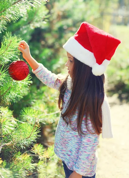 Jul och människor koncept - litet barn i santa röd hatt vett — Stockfoto