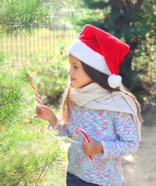 Jul och människor koncept - barn i santa röd mössa med sweet — Stockfoto