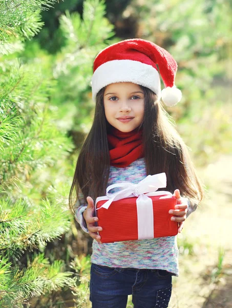 Christmas child in santa red hat with gift box — Stock Photo, Image