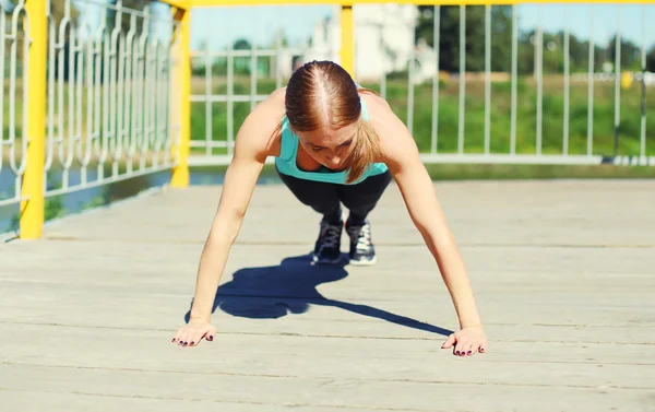 Esporte, conceito de fitness - mulher fazendo push-ups exercício na cidade — Fotografia de Stock