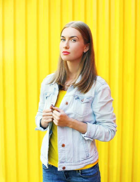Модная симпатичная женщина в джинсовой куртке поверх цветного трико — стоковое фото