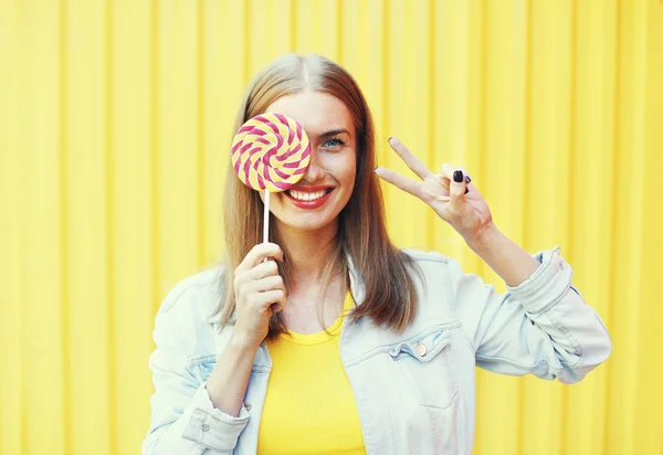 Retrato feliz sonriente mujer con dulce caramelo piruleta sobre co — Foto de Stock