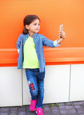 Happy little girl child taking picture self portrait on smartpho