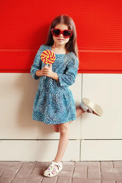 Criança menina bonita com pirulito vestindo um leopardo dres — Fotografia de Stock