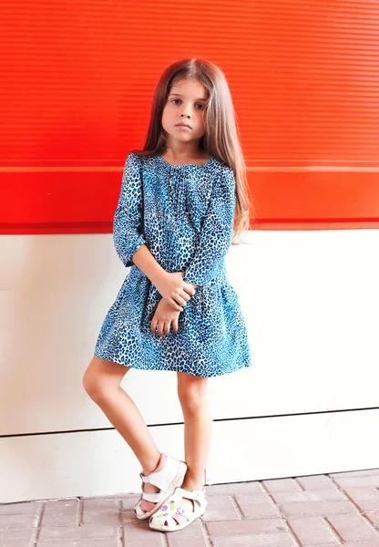 Üzerinde kırmızı bac bir leopar elbise giyen güzel küçük kız çocuk — Stok fotoğraf