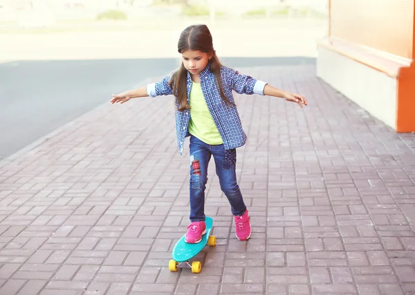Fashion kid, little girl riding on skateboard in city — Stockfoto