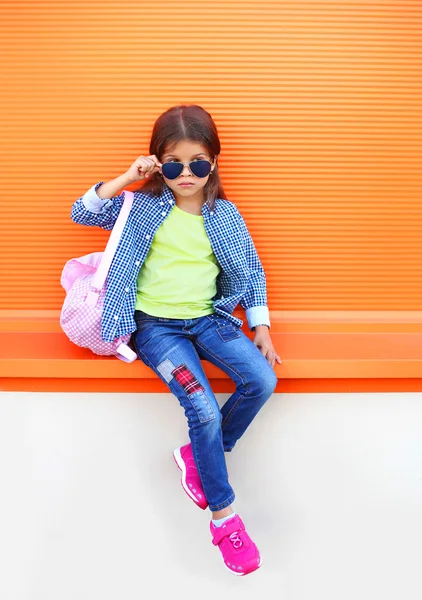 Moda menina criança vestindo um óculos de sol, camisa, jeans e — Fotografia de Stock